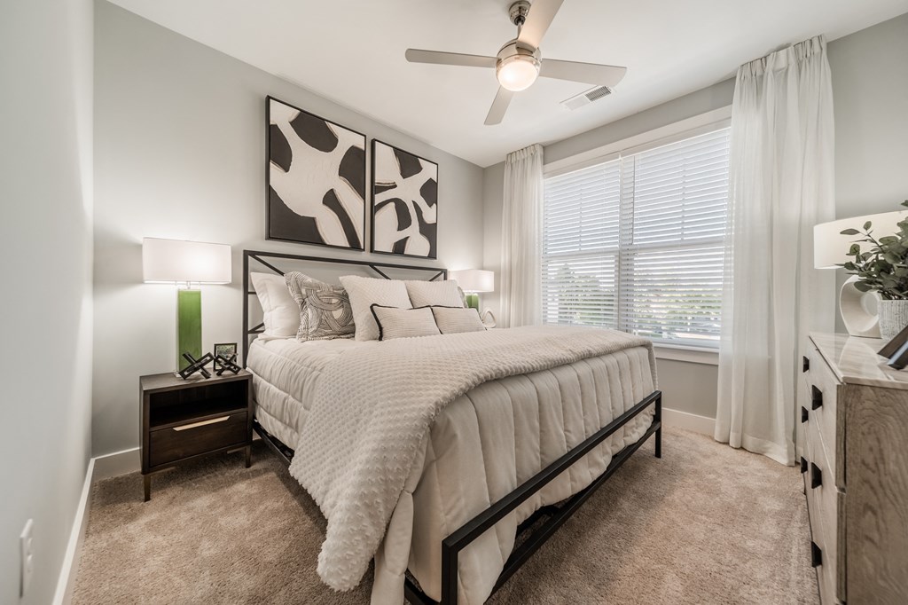a bedroom with a large bed and a ceiling fan