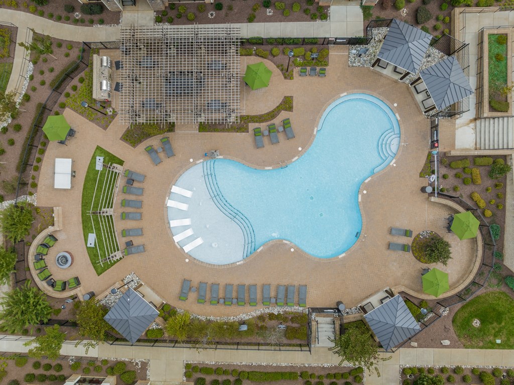 an overhead view of a swimming pool in front of a resort pool