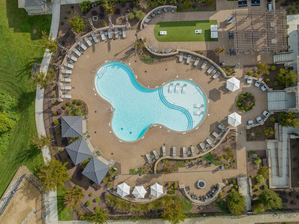 an overhead view of a swimming pool at a resort with umbrellas