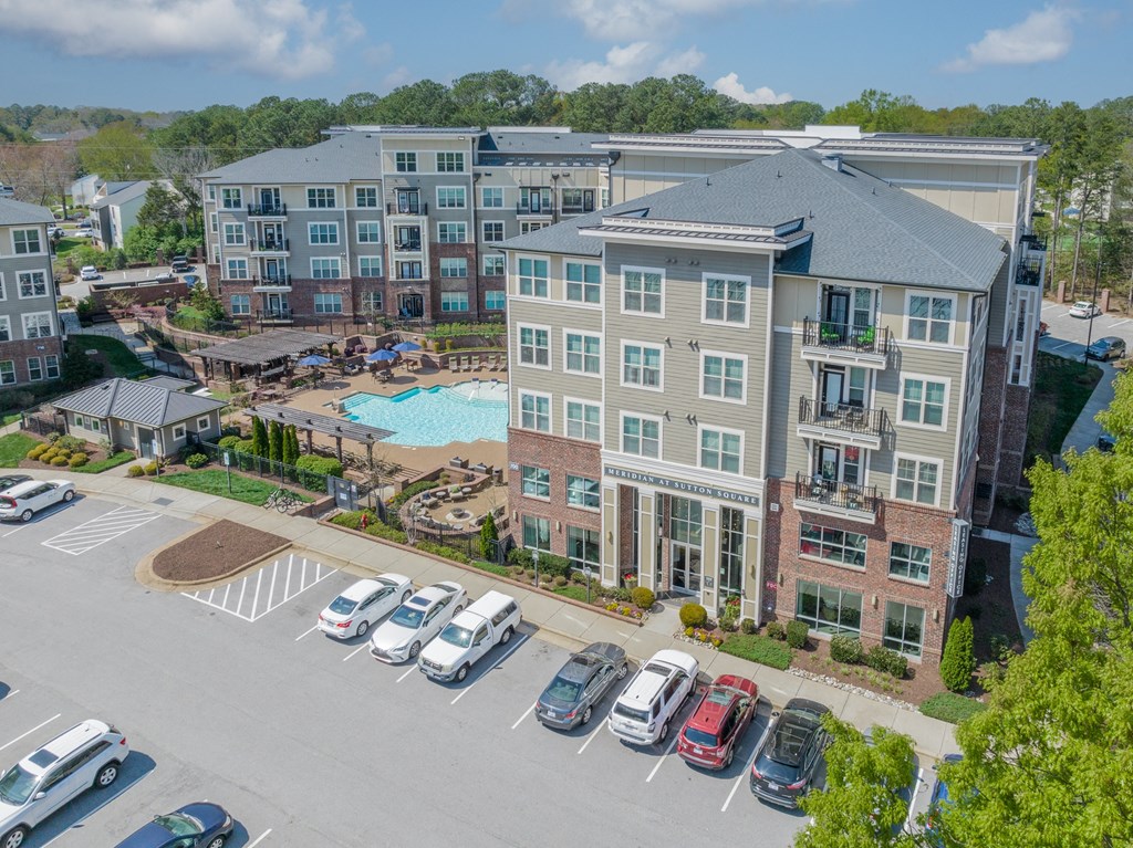an aerial view of a large apartment complex with a swimming pool and parking lot