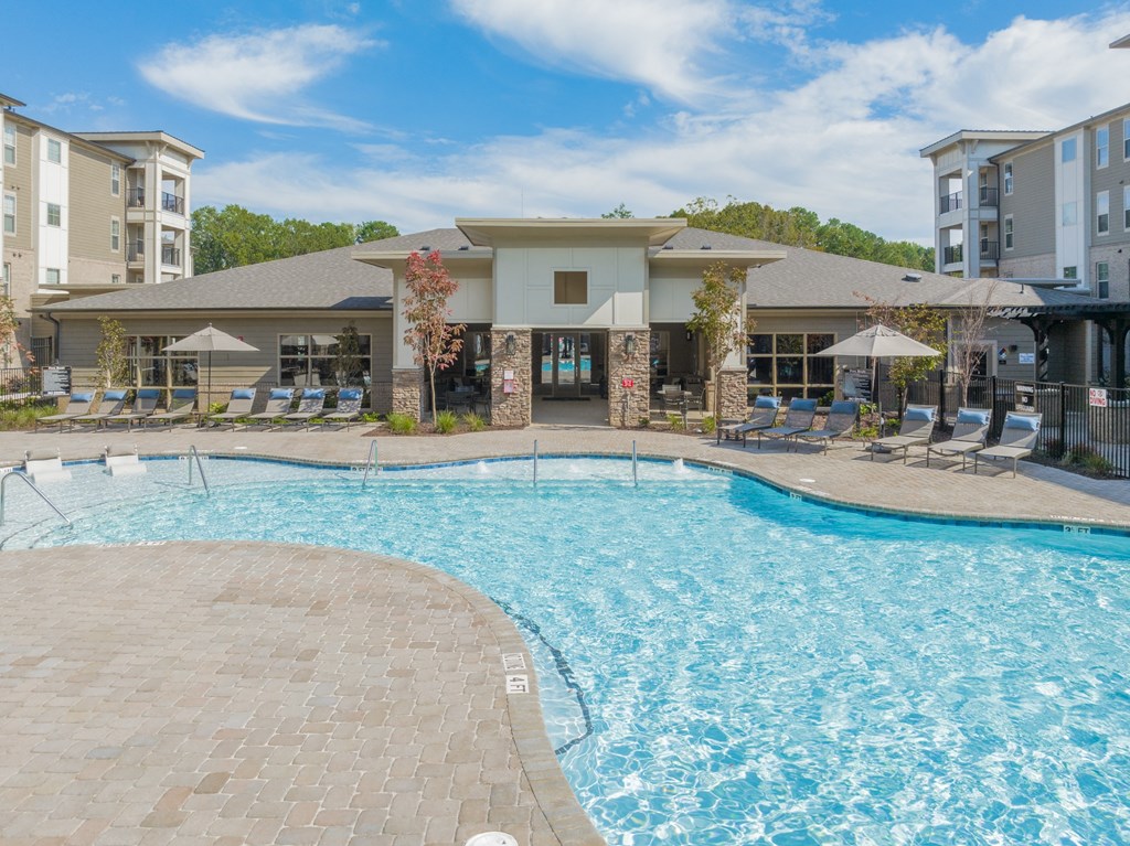 our apartments have a resort style pool with chairs and umbrellas