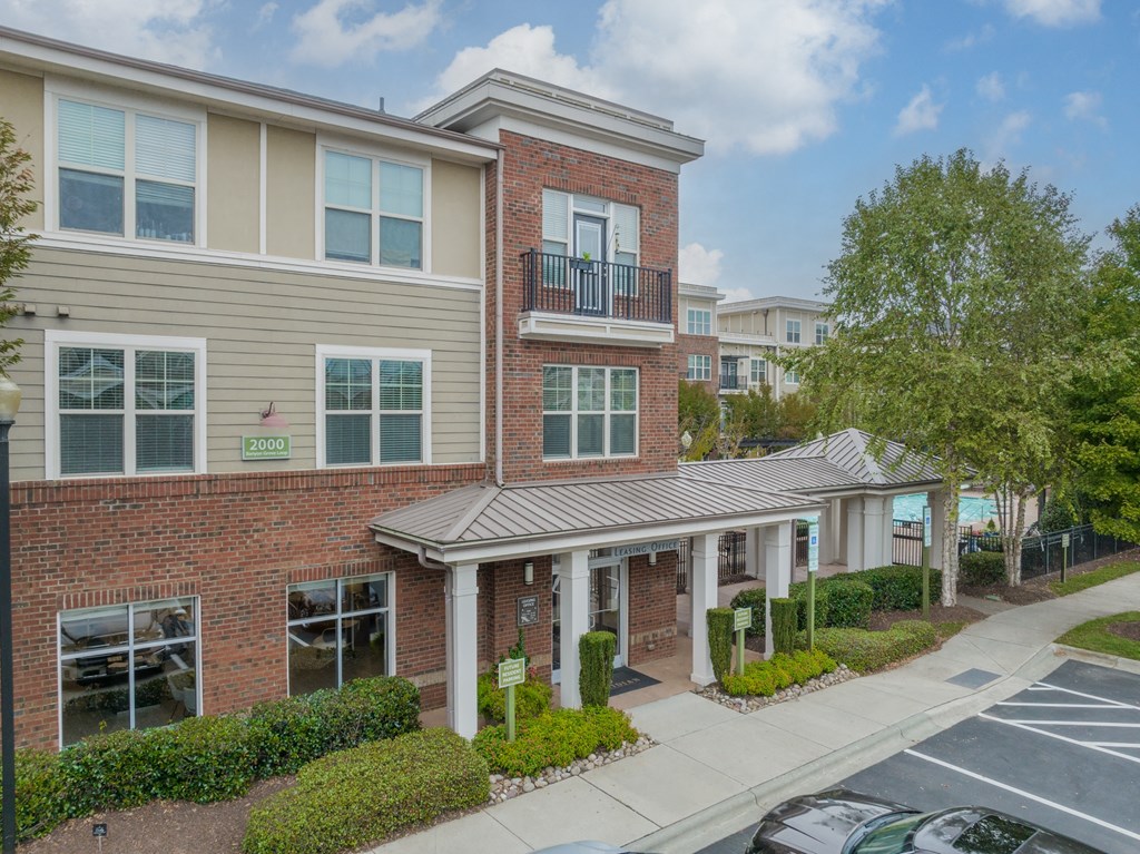 an apartment building with a sidewalk and a parking lot