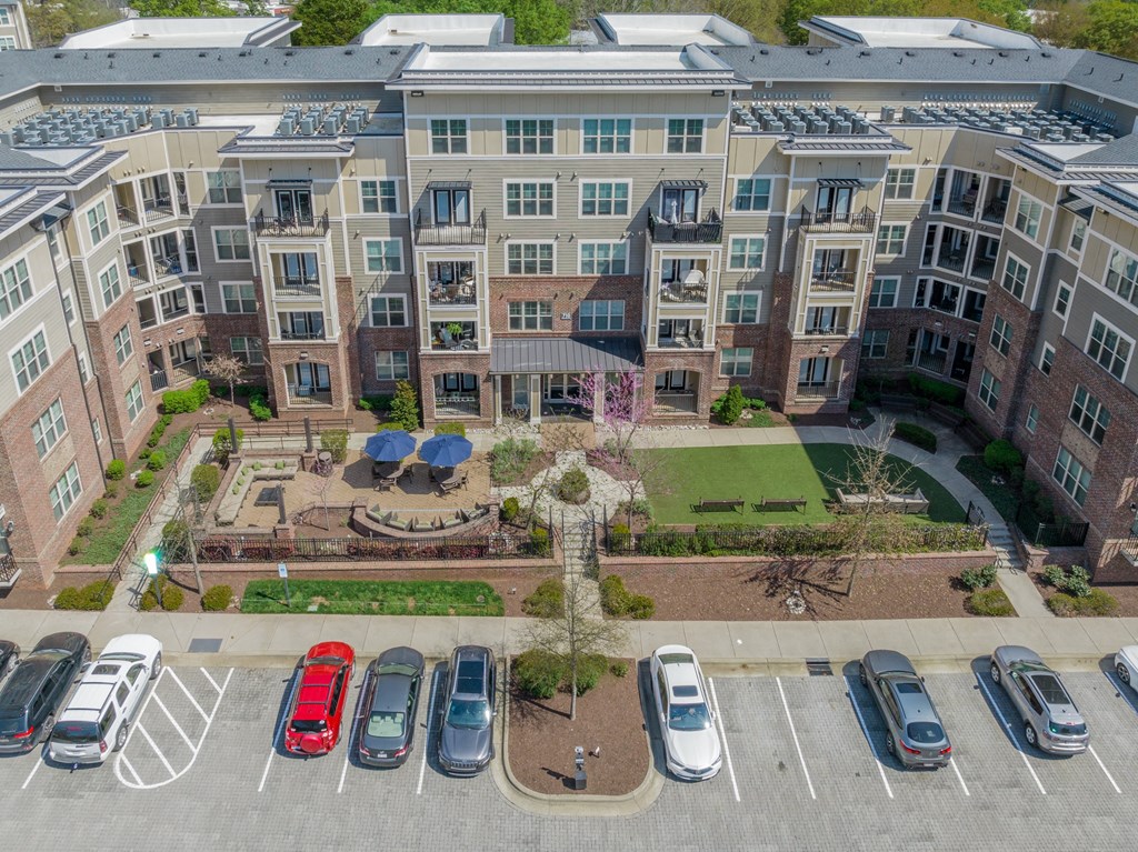 an aerial view of a large apartment complex with cars parked in front of it
