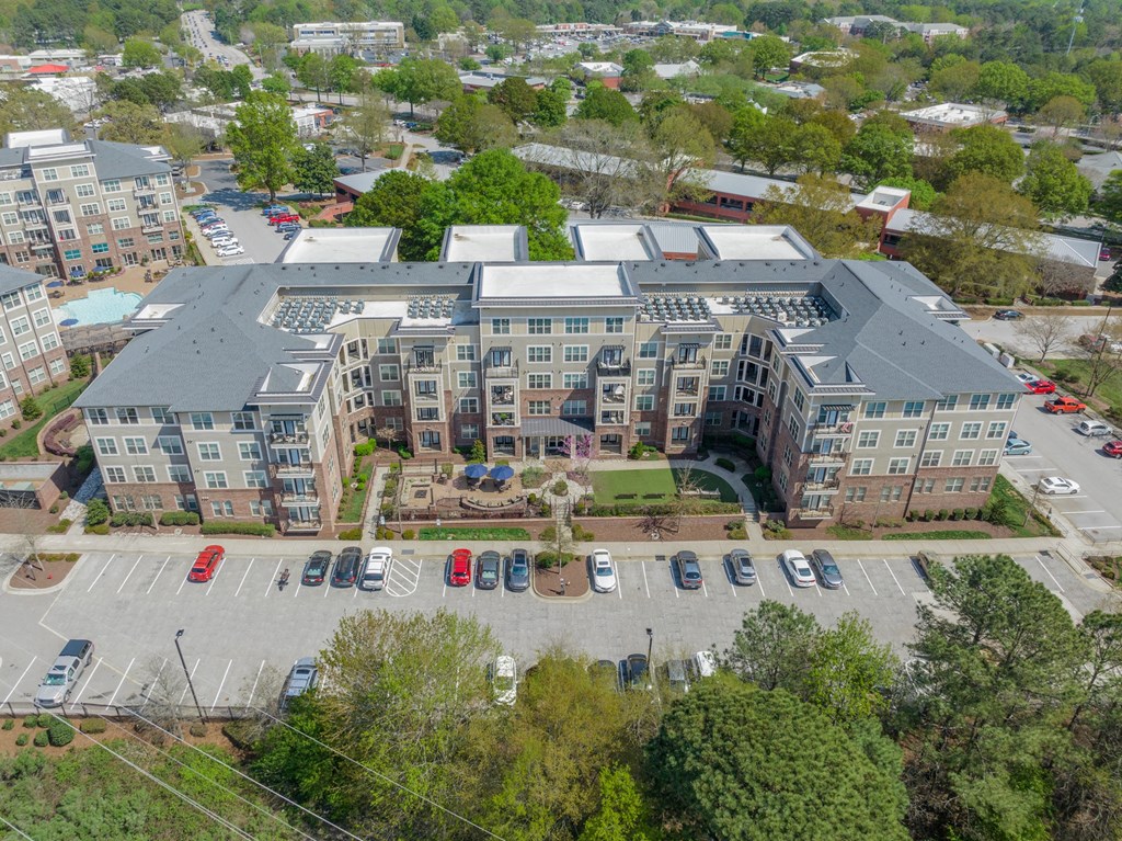 an aerial view of a large apartment complex with cars parked in the parking lot