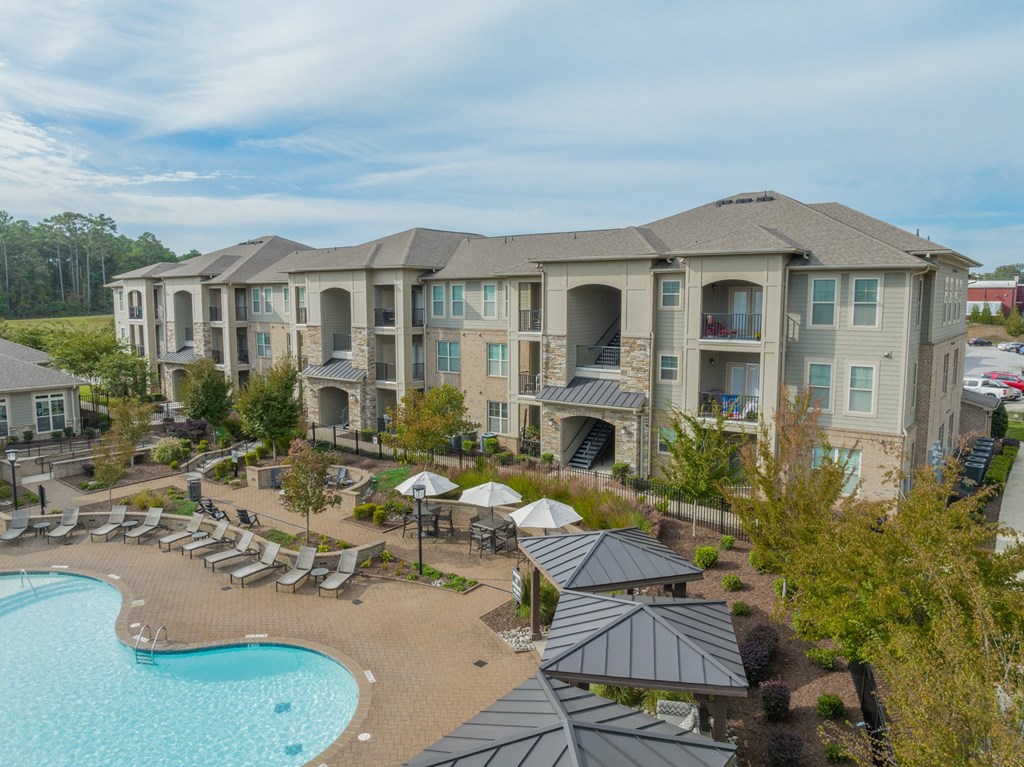 an aerial view of the resort with a pool and umbrellas