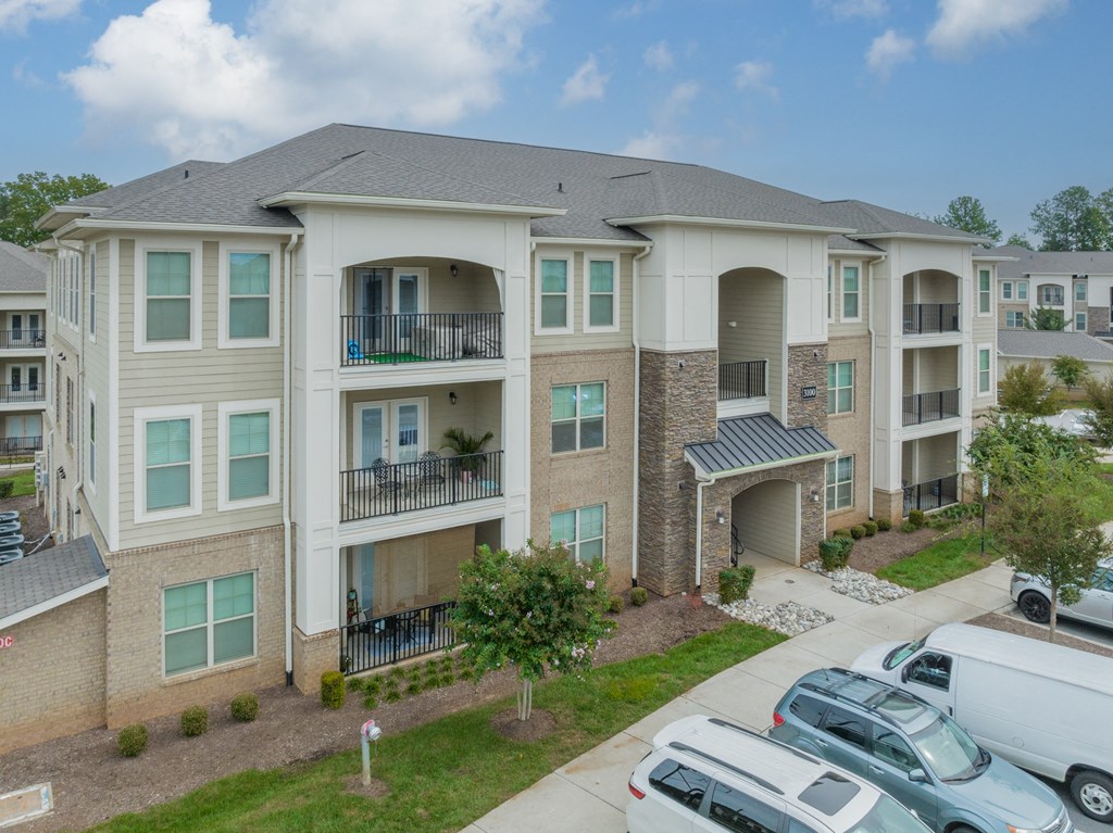 an apartment building with cars parked in front of it