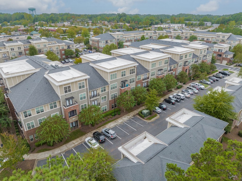 an aerial view of an apartment complex with cars parked in a parking lot