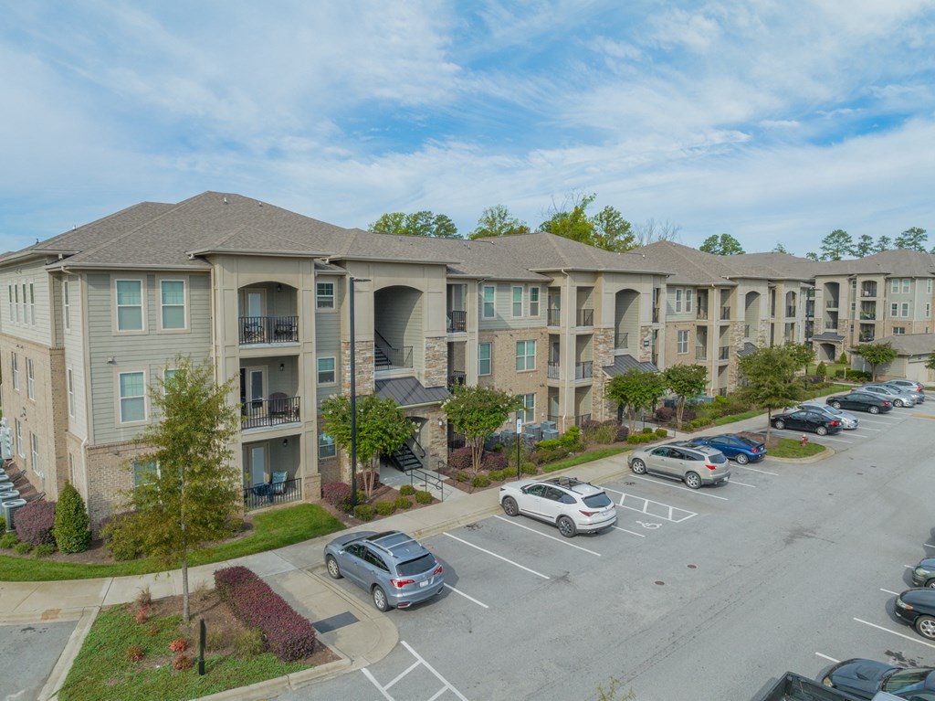 an aerial view of an apartment complex with cars parked in a parking lot