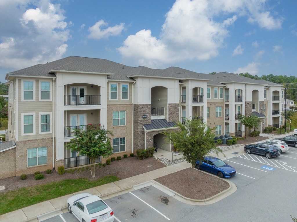 a large apartment building with cars parked in a parking lot