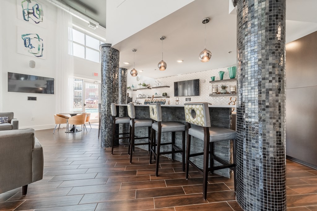 a kitchen with a bar and stools in front of a large window