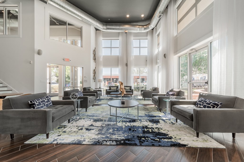 a living room with couches and chairs and a rug