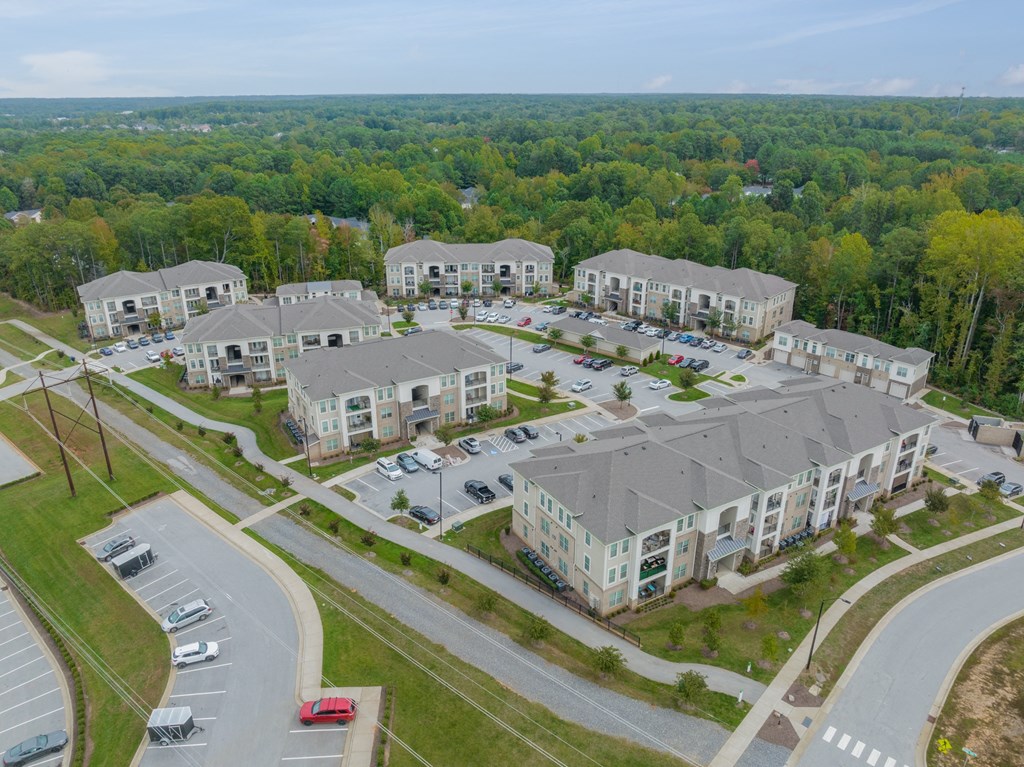 an aerial view of an apartment complex with cars parked in a parking lot