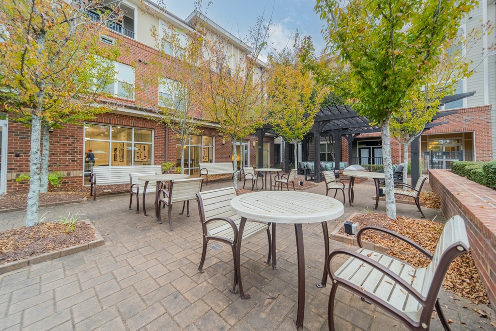a patio with tables and chairs outside of a brick building