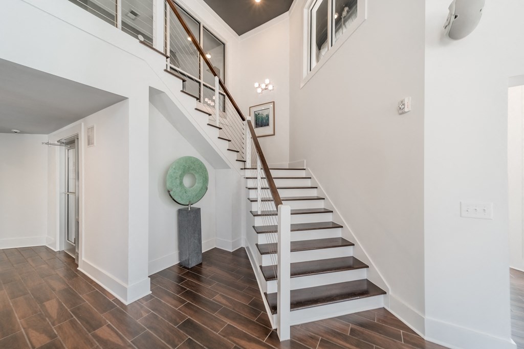 a stairway in a house with white walls and a green plate on the floor