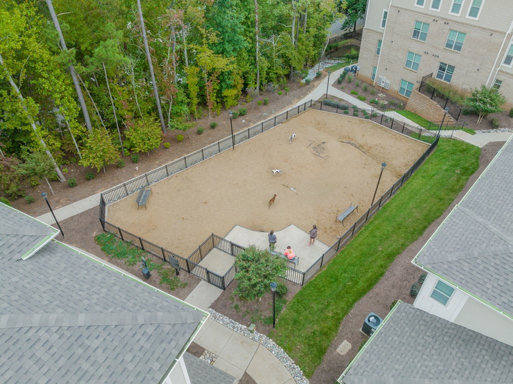 an aerial view of a fenced in dog park in a residential neighborhood
