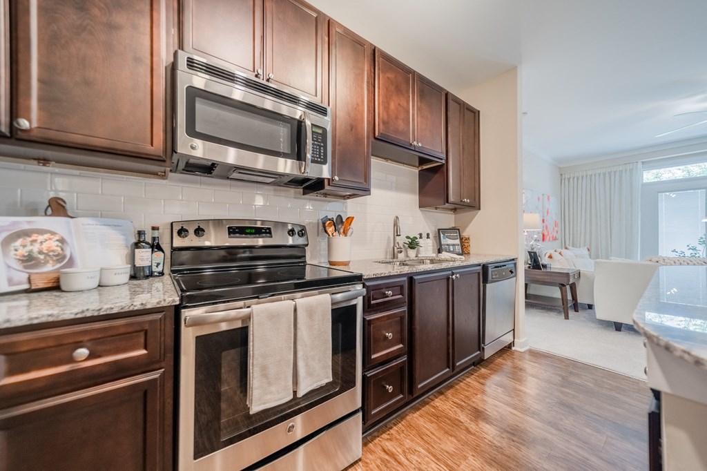 a kitchen with dark wood cabinets and stainless steel appliances