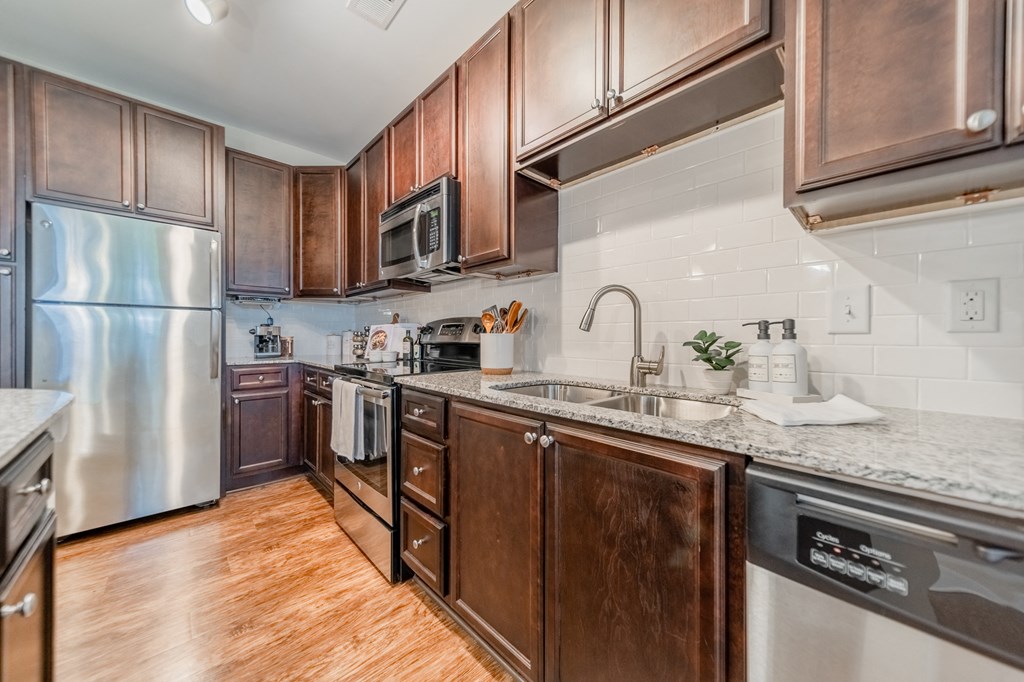 a kitchen with wooden cabinets and stainless steel appliances