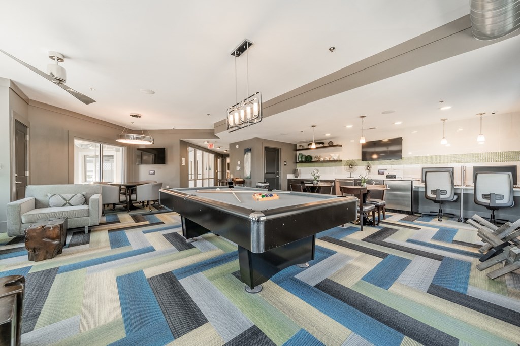 a spacious game room with a pool table and ping pong table