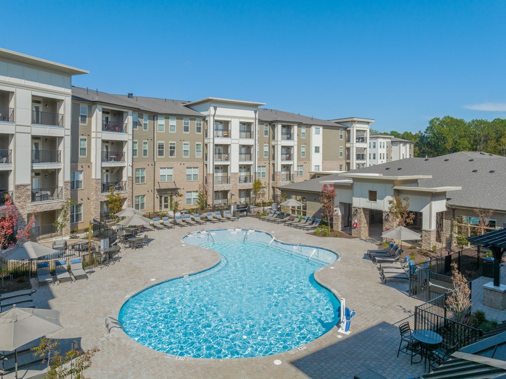 a swimming pool with an apartment building in the background