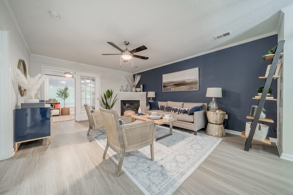 a living room with a blue accent wall and a ceiling fan