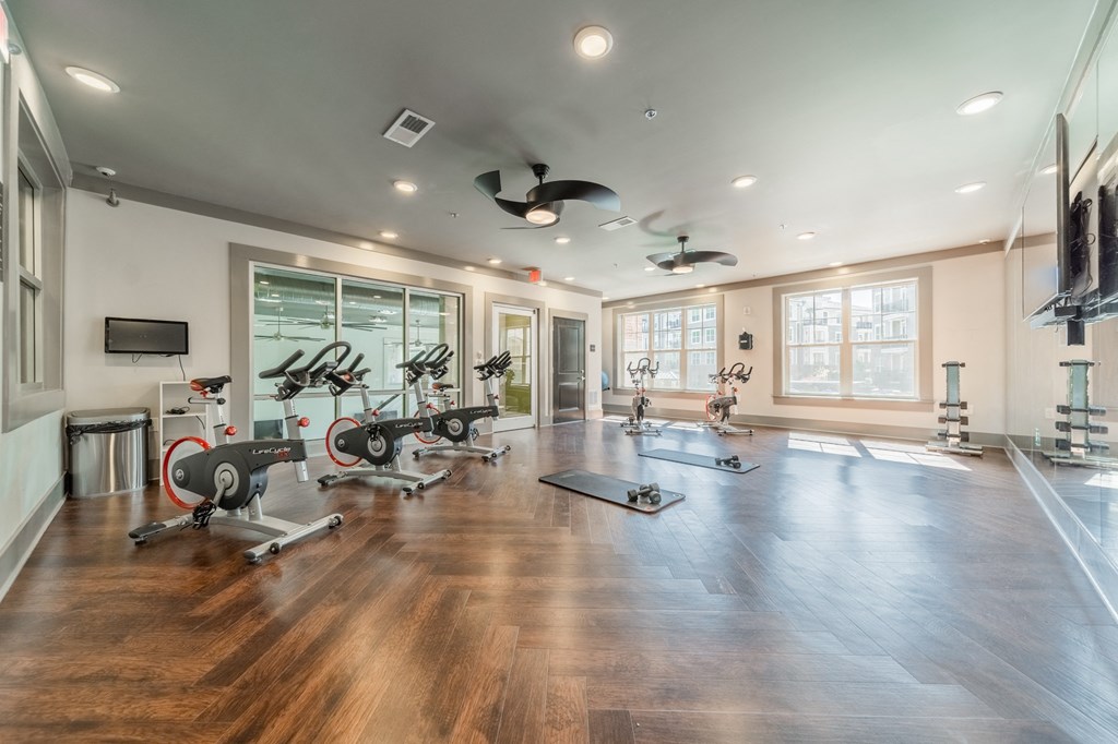 a home gym with exercise machines and a tv on the wall