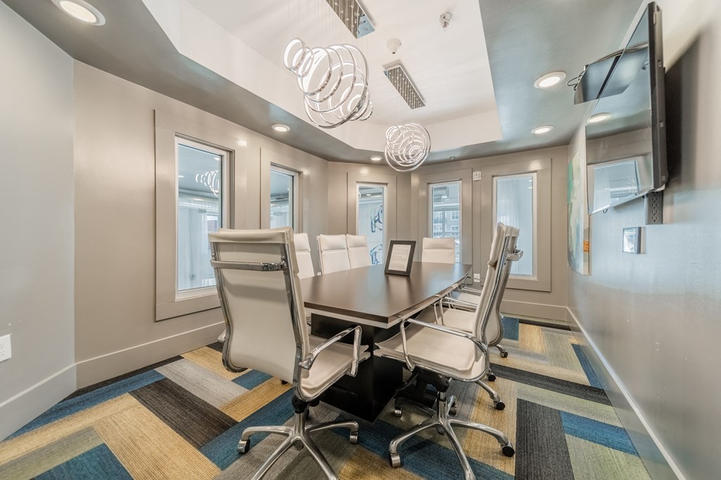 a conference room with a long table and chairs and a flat screen tv on the wall