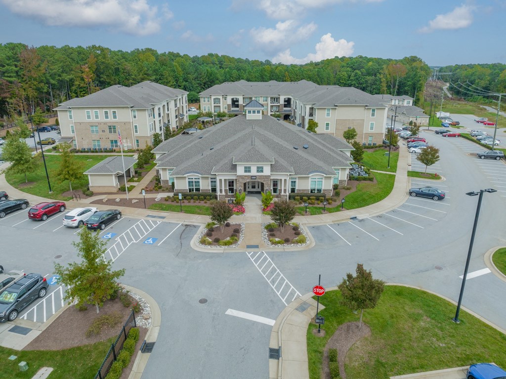 an aerial view of a parking lot with apartments in the background