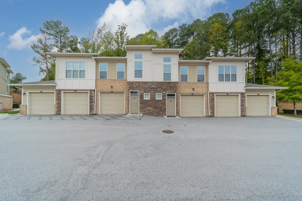 a large white and tan house with garage doors