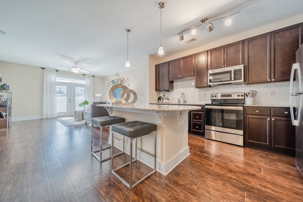 a kitchen with a large island with two stools in front of it