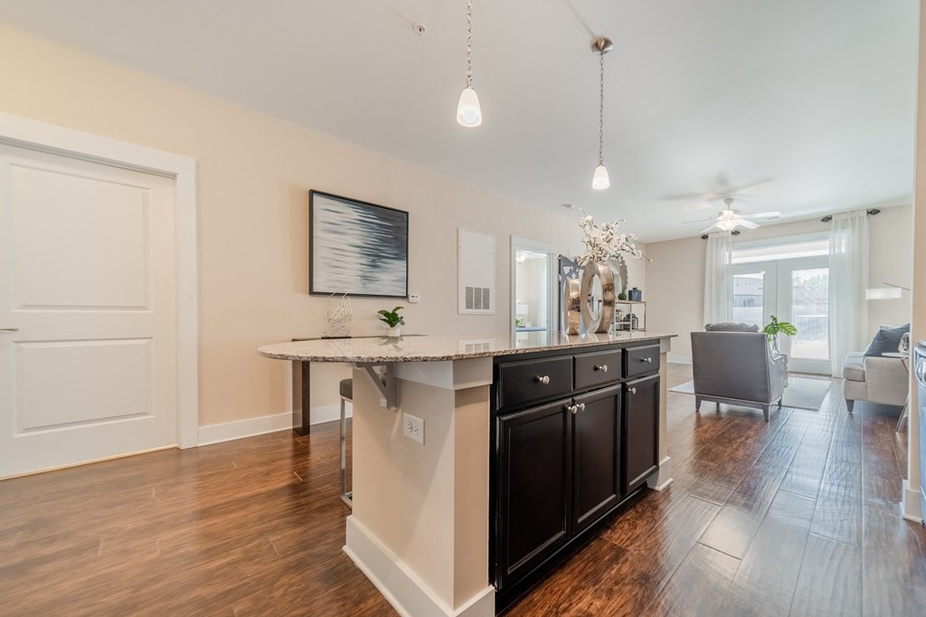 a kitchen with an island and a living room in the background