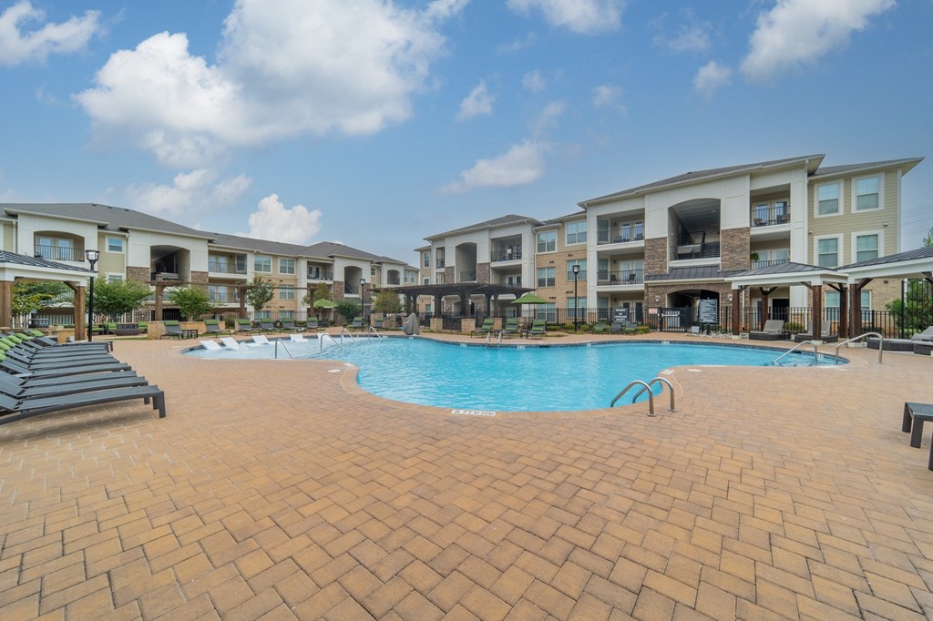 a large swimming pool in front of an apartment building