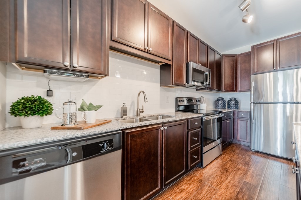 a kitchen with wooden cabinets and stainless steel appliances