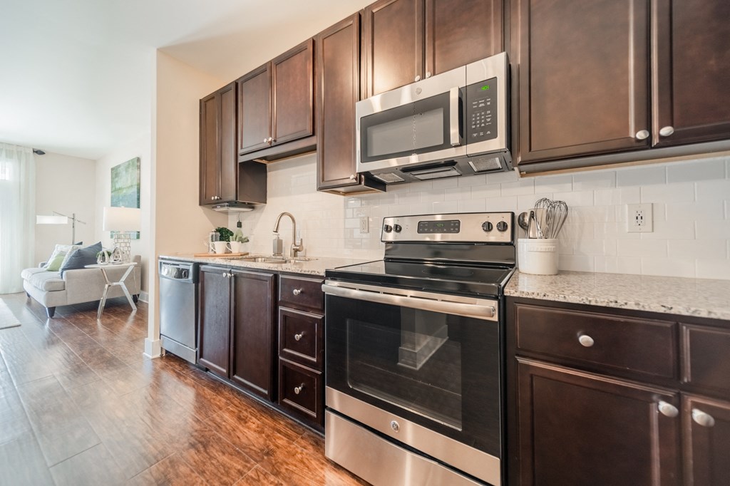 a kitchen with dark wood cabinets and stainless steel appliances