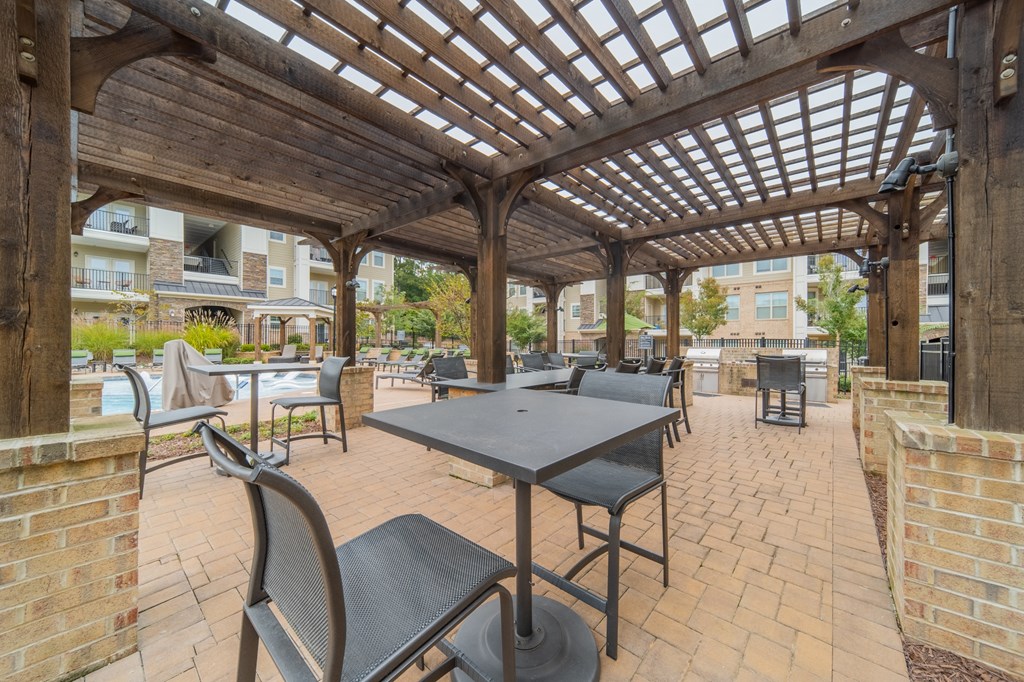 a patio with tables and chairs and a pergola