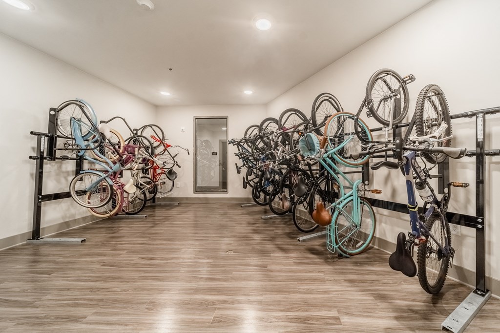 a row of bikes hanging on the wall in a room with wooden floors