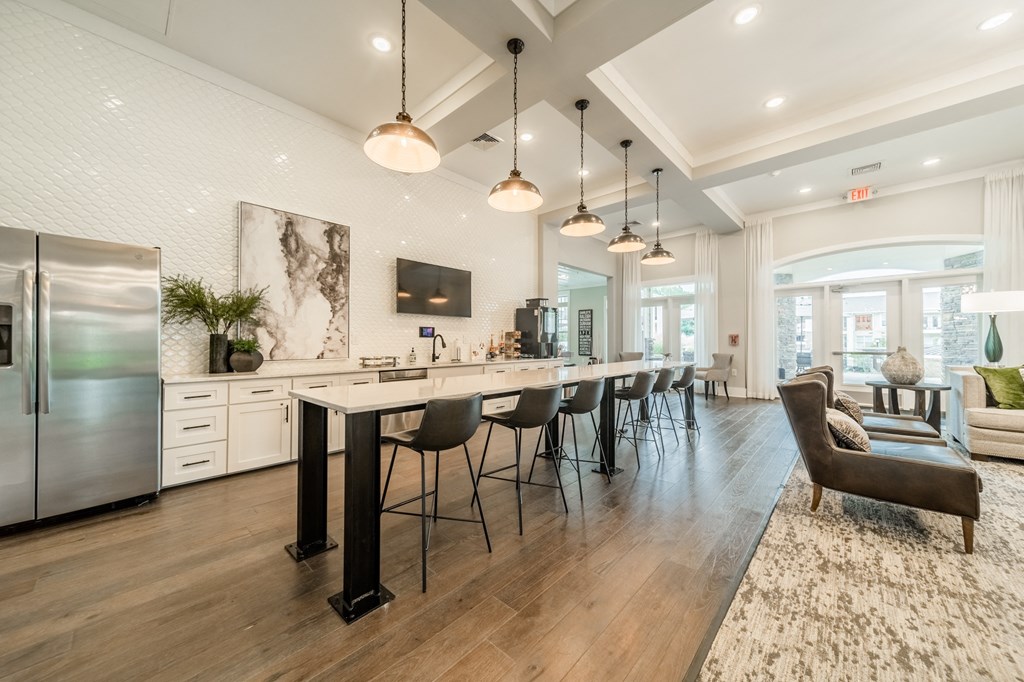the gathering room and kitchen of a new home with a large island and chairs