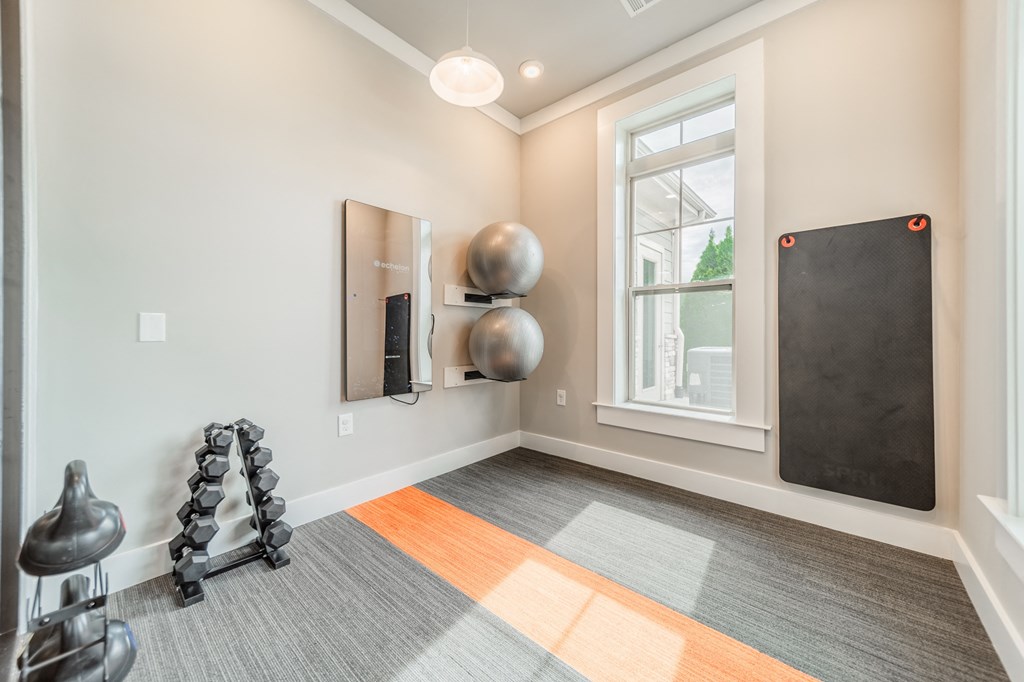 a workout room with exercise equipment and a window