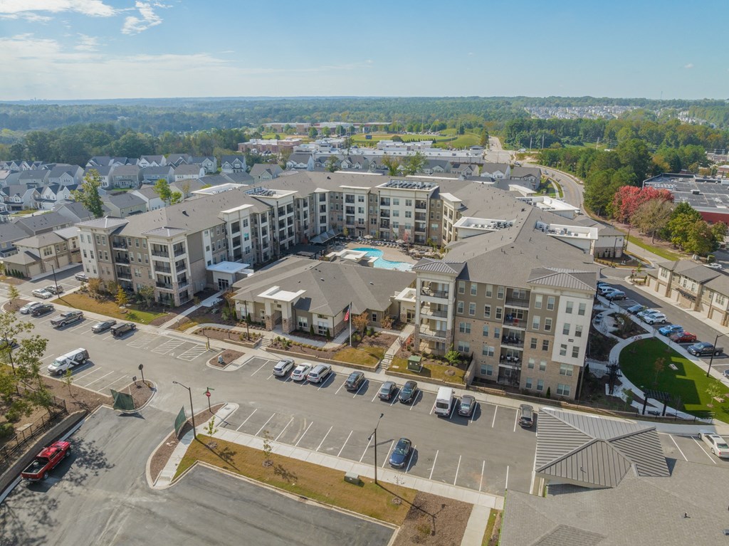 an aerial view of an apartment complex with cars parked in a parking lot