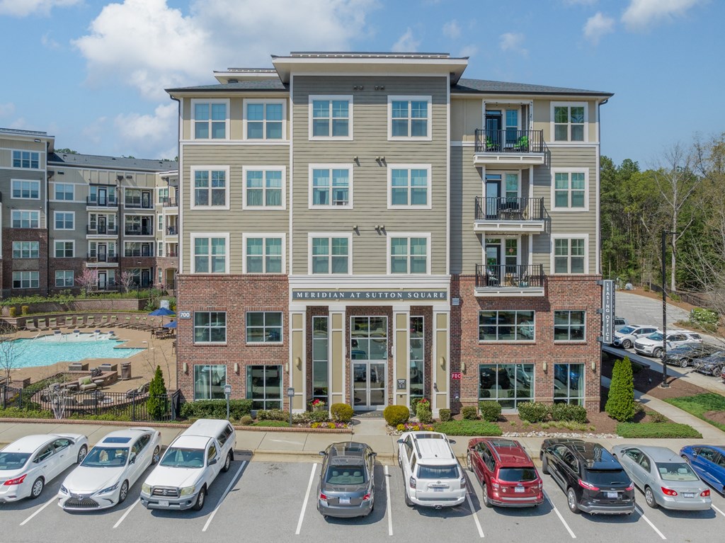a large apartment building with a parking lot in front of it