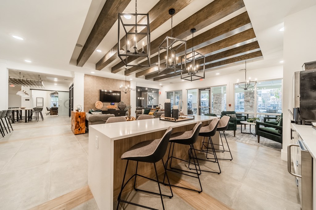 the kitchen and living room of a home with an island and bar stools