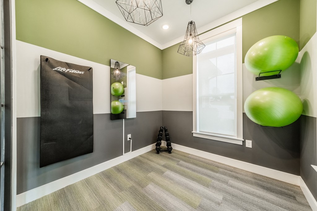 a gym with a large green ball on the wall and a window