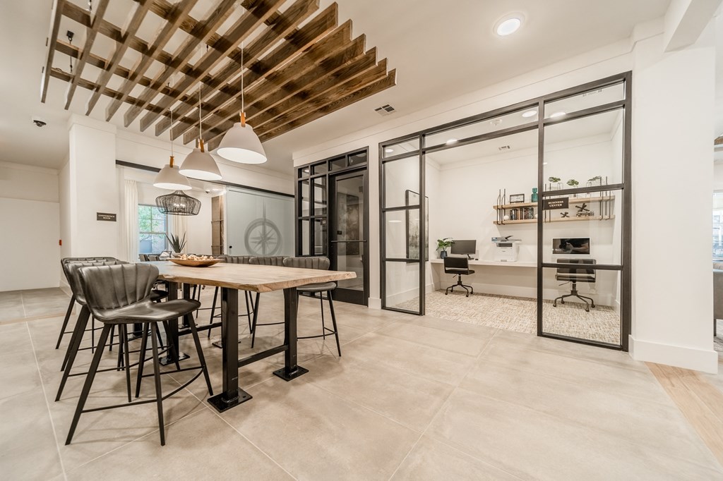 a dining area with a wooden table and chairs and a kitchen with glass doors