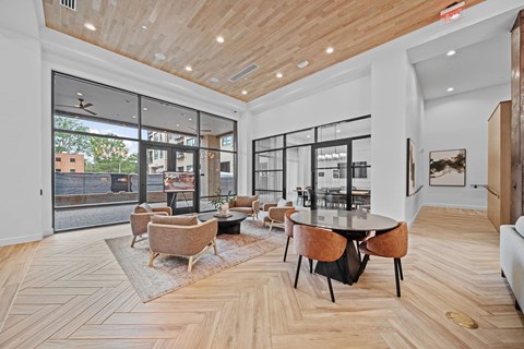 A modern living room with a wooden floor and a glass wall.