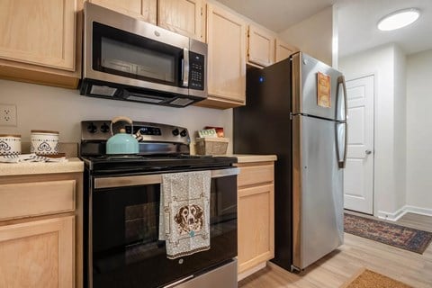 A kitchen with a black stove top oven and black microwave above it.