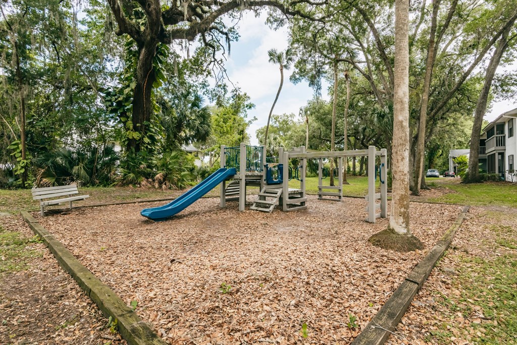 a playground with a slide and benches in a park
