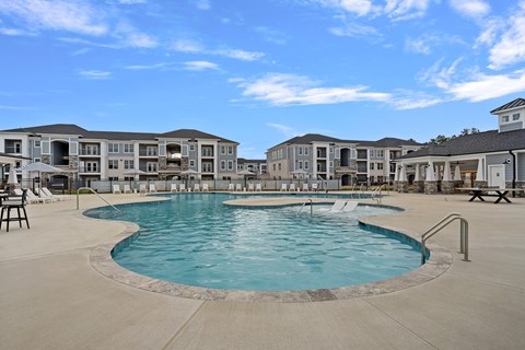 A large swimming pool in front of apartment buildings.