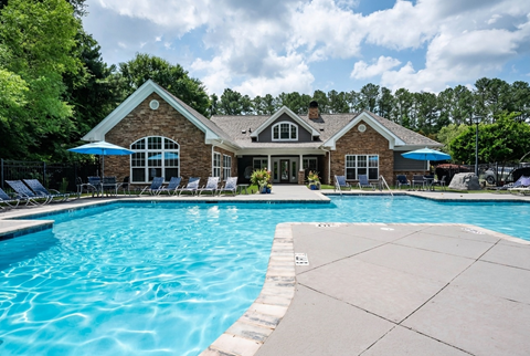 A house with a pool in front of it.