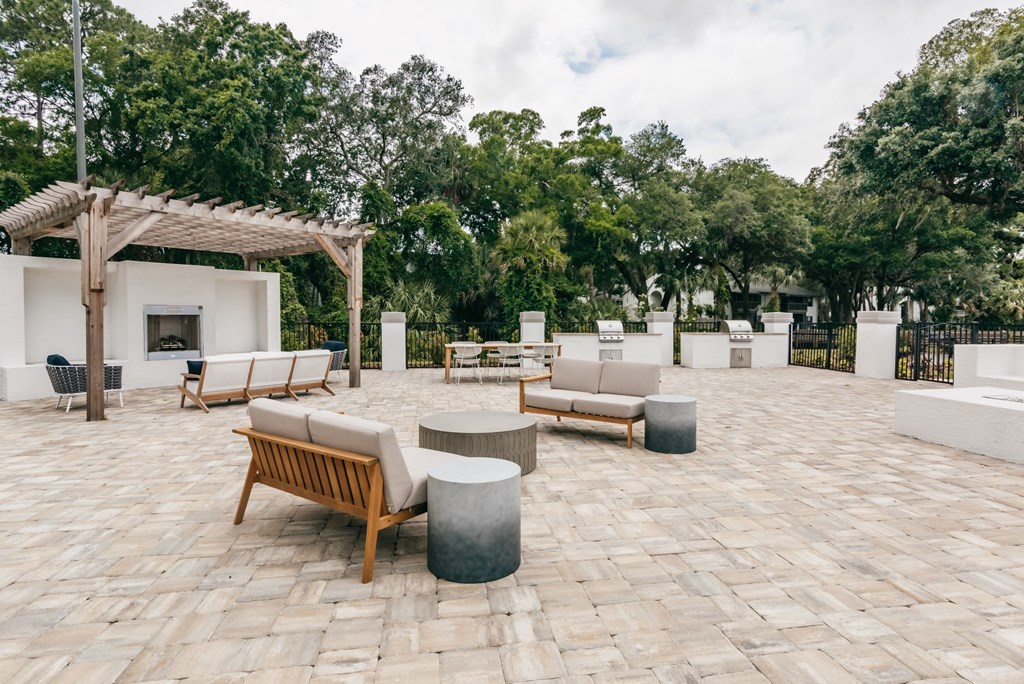 a seating area with couches and tables on a brick patio