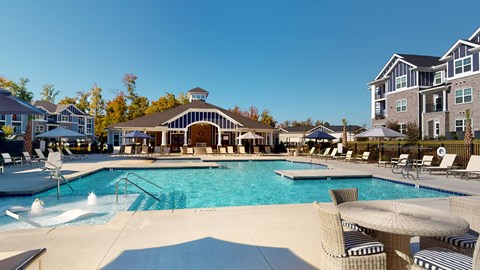 A large swimming pool with a slide and a building in the background.