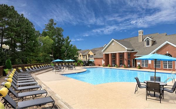 A pool surrounded by lounge chairs and umbrellas.